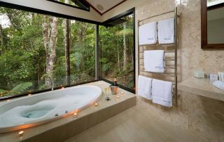 The Creekside Spa Cabins have full marble bathrooms with double spa baths with floor-to-ceiling rainforest views